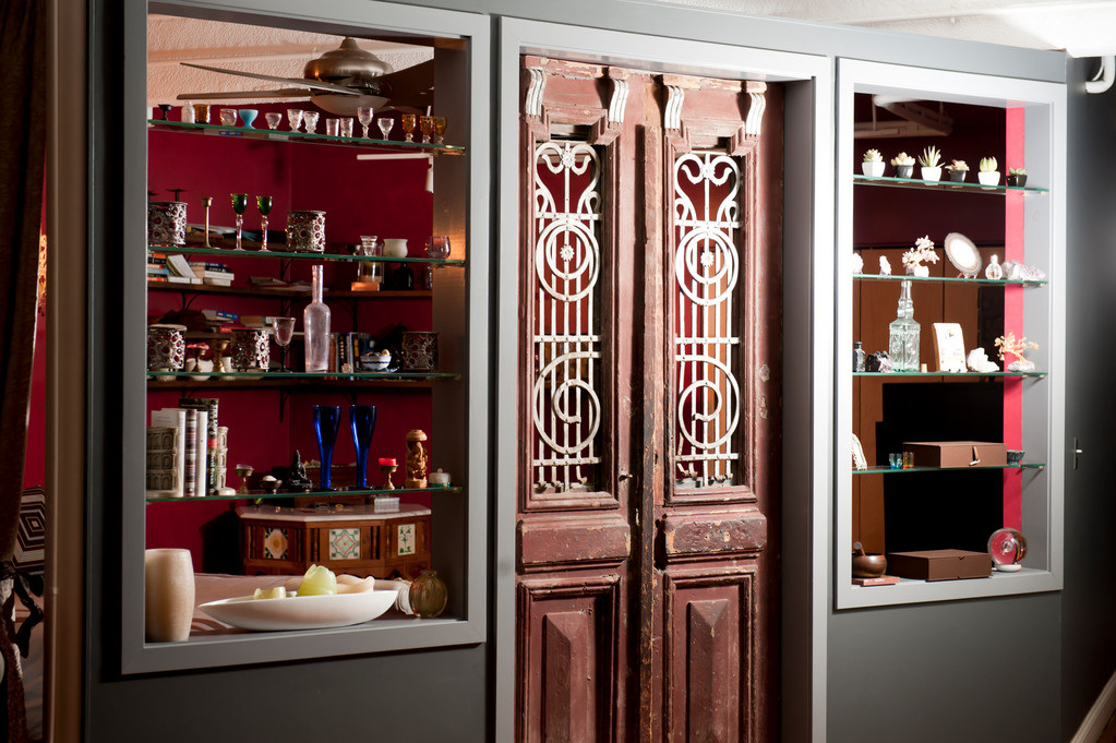 "Those are antique Egyptian doors I bought at Kyureo here in Providence. I had the wall built around the doors. The objects on the glass shelves are mostly glass and statues I have collected in markets I visit when I travel."