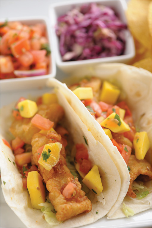 Fish Tacos: Lightly battered fish topped with mango salsa and charred cabbage