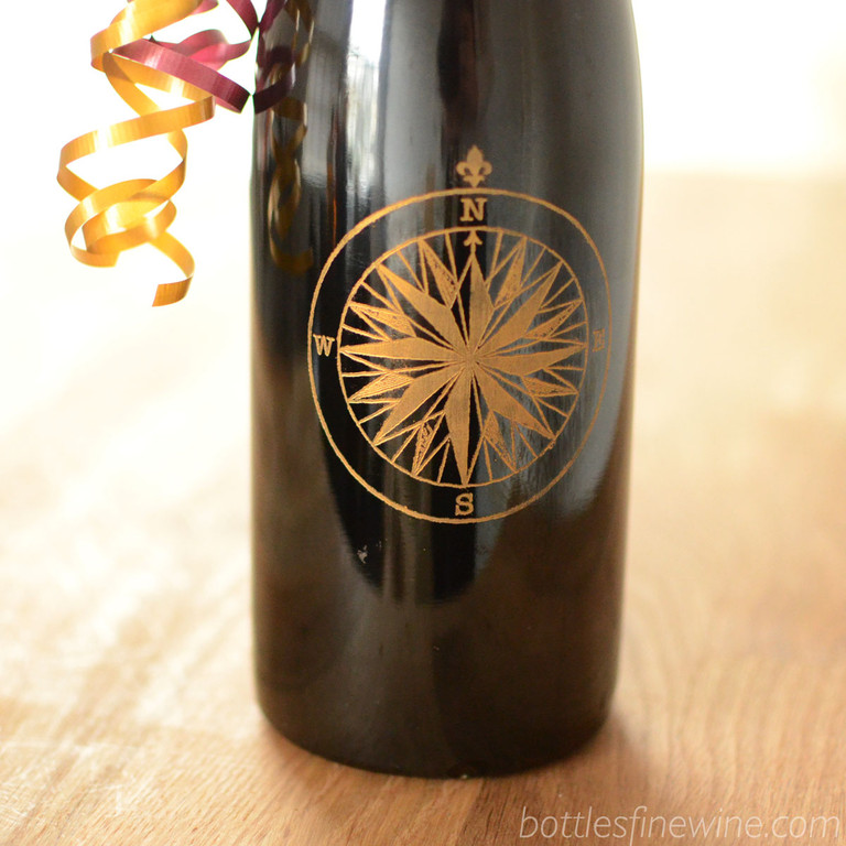 A detailed compass design engraved on a red wine bottle. Add a personalized message underneath for just $15. Order now!