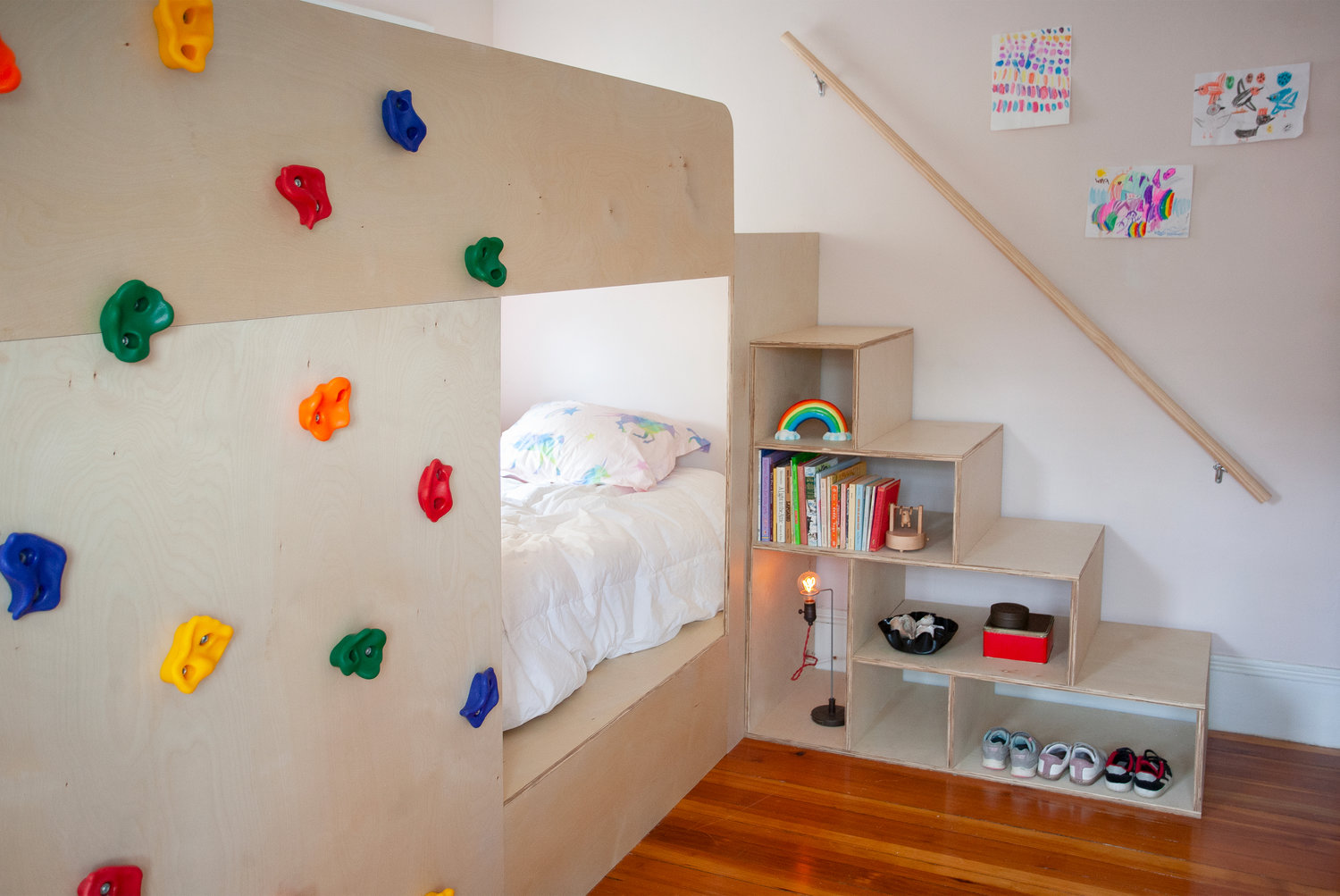 A climbing wall steps in for a ladder and makes space for storage