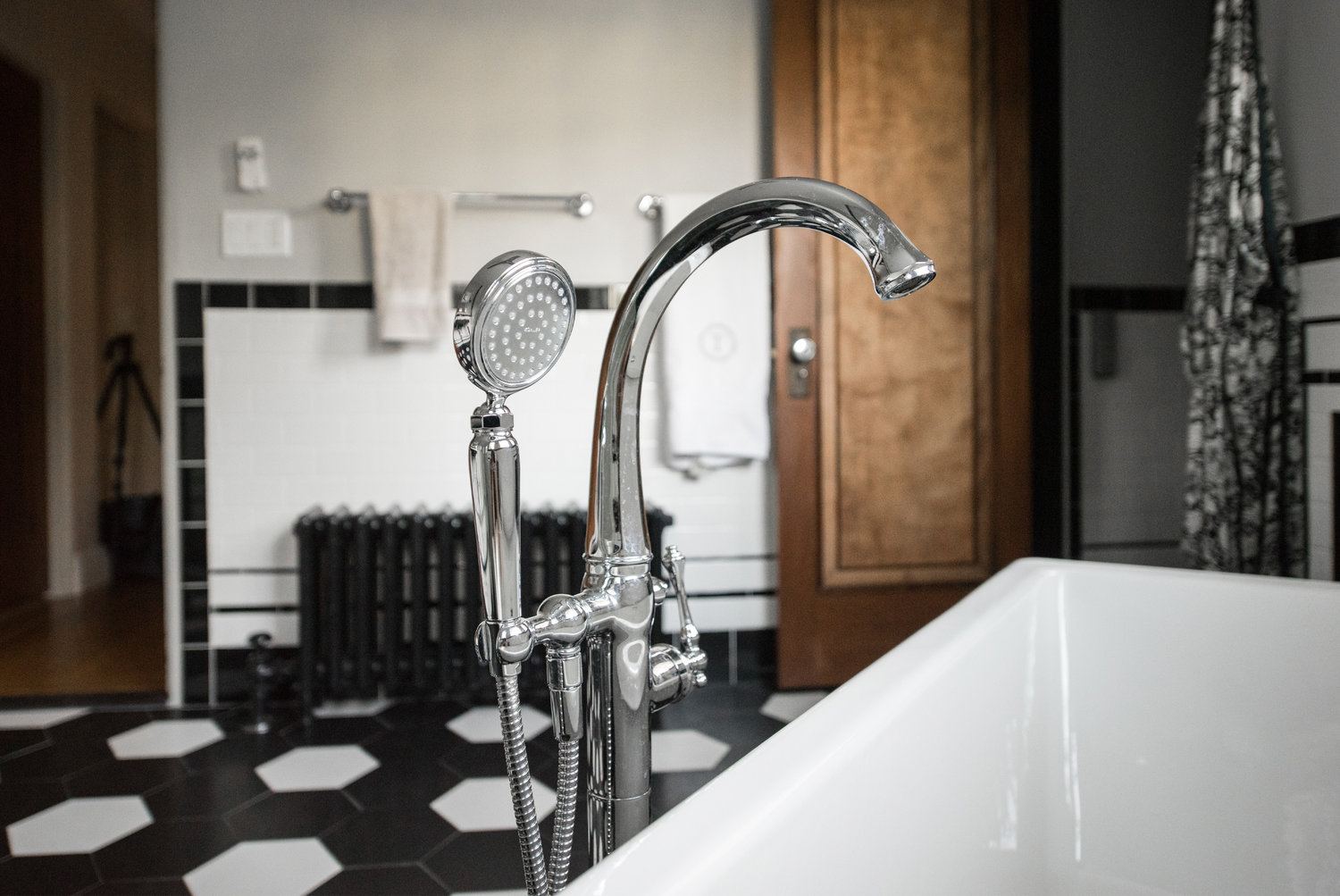A floor-mounted tub filler was used for the new cast iron freestanding tub and plays off the lines of the sink console